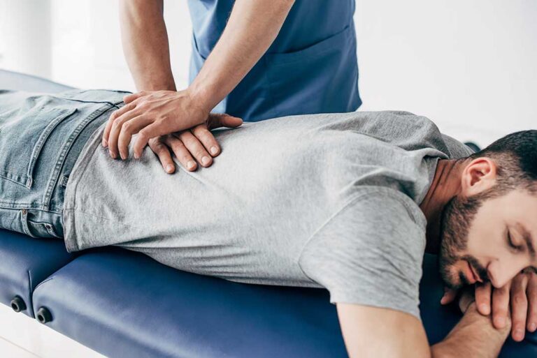A chiropractor gently adjusting a person's back in a comfortable clinic setting.